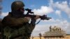 An Israeli soldier looks through the scope of his weapon outside the southern Gaza Strip, July 17, 2014.