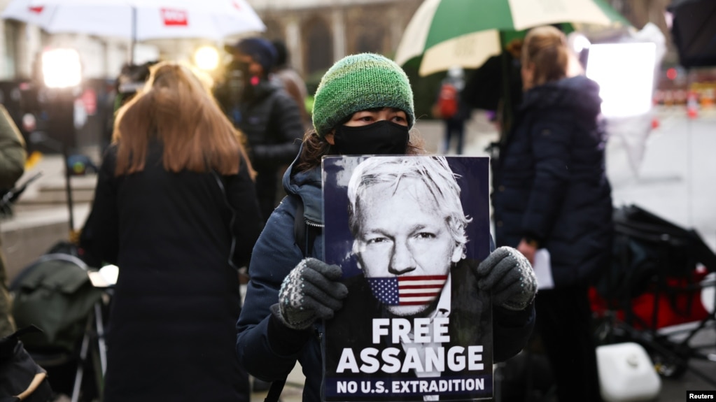 Người ủng hộ ông Julian Assange mang hình ảnh ông đứng trước toà án hình sự ở London, Anh, vào ngày 41/2021. 