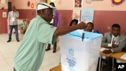 A voter casts his vote in elections in Luanda, Angola, Aug. 23, 2017. 