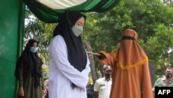 Seorang perempuan dicambuk 100 kalo karena zina di Idi, Aceh Timur