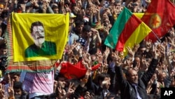 FILE - Demonstrators wave various PKK flags and images of jailed Kurdish rebel leader Abdullah Ocalan in the southeastern Turkish city of Diyarbakir, March 21, 2013. 