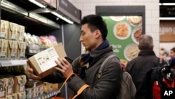 Customer Paul Fan shops at an Amazon Go store Monday, Jan. 22, 2018, in Seattle. (AP Photo/Elaine Thompson)