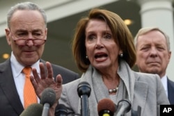 FILE - House Speaker Nancy Pelosi, center, speaks as she stands next to Senate Minority Leader Sen. Chuck Schumer, left, and Sen. Dick Durbin right, following their meeting with President Donald Trump at the White House in Washington, Jan. 9, 2019.
