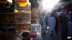 File - Afghans walk through a market in Kabul, Afghanistan. With Afghan assets frozen in the U.S. and the world reluctant to recognize the Taliban, the country's banking system has come to a halt, Oct. 12, 2021.
