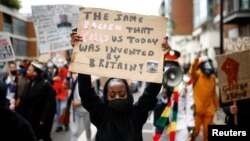 Người biểu tình giơ biểu ngữ trong khi họ tuần hành trong một cuộc biểu tình Black Lives Matter ở London, Anh, ngày 6 tháng 6, 2020.