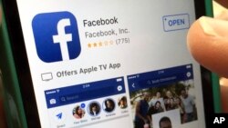 FILE - A user gets ready to launch Facebook on an iPhone, in North Andover, Massachusetts, June 19, 2017. Apple says it has banned a Facebook-made app that paid users, including teenagers, to extensively track their data. 