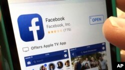 FILE - A user gets ready to launch Facebook on an iPhone, in North Andover, Mass., June 19, 2017. Facebook has made changes to fight false information, including de-emphasizing proven false stories in people's feeds so others are less likely to see them. 