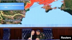 FILE - Russian President Vladimir Putin listens to Chief of the General Staff of Russian Armed Forces Valery Gerasimov during a meeting in Moscow, Russia, Dec. 21, 2021. A partial map of Ukraine with Russia-annexed Crimea is seen behind them.