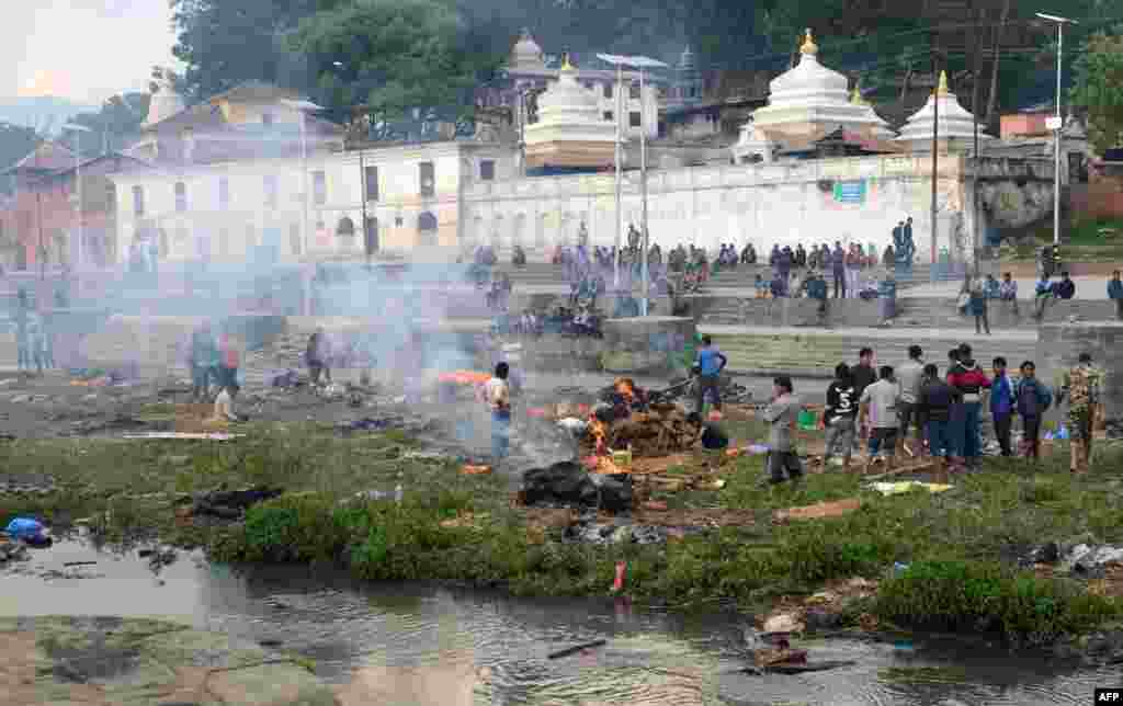 Warga Nepal membakar korban tewas gempa bumi dalam upacara kremasi massal di distrik Pashupatinath, Kathmandu, Nepal.