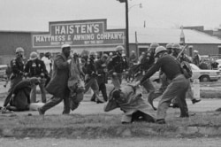 State troopers swing billy clubs to break up a civil rights voting march in Selma, Ala., March 7, 1965. John Lewis, chairman of the Student Nonviolent Coordinating Committee (in the foreground) is being beaten by a state trooper.