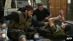 Syrian rebel fighters evacuate a wounded comrade during fighting with government troops in the old city of Aleppo, September 28, 2012. 