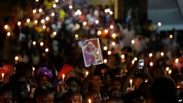 Católicos ugandeses esperan con cirios encendidos la llegada del papa Francisco para una reunión con catequistas y profesores durante su visita Munyonyo, Uganda. Viernes 27 de noviembre de 2015.