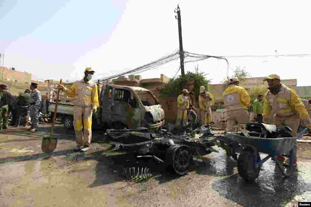 Municipality workers clean the site of a bomb attack in Baghdad, March 5, 2014.