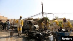 Municipality workers clean the site of a bomb attack in Baghdad, March 5, 2014.