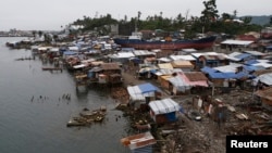 FILE - A view of temporary shelters for typhoon survivors that were constructed next to a ship that ran aground is pictured nearly 100 days after super Typhoon Haiyan devastated Tacloban city in central Philippines, Feb. 14, 2014. 