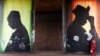 A woman stands in front of a poster in Bamako, Mali, Feb. 21, 2014.