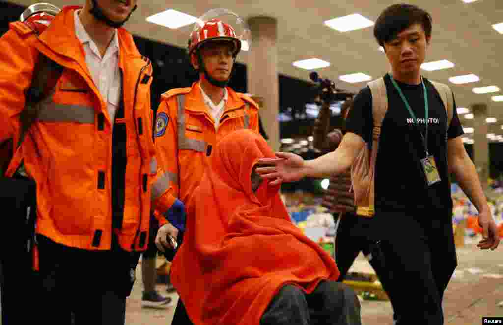 Paramédicos escoltan a un manifestante a una ambulancia en el campus de la Universidad Politécnica (PolyU) en Hong Kong, China, 24 de noviembre de 2019.