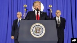 President Donald Trump, accompanied by Vice President Mike Pence, left, and Homeland Security Secretary John F. Kelly, pauses while speaking at the Homeland Security Department in Washington, Jan. 25, 2017. 