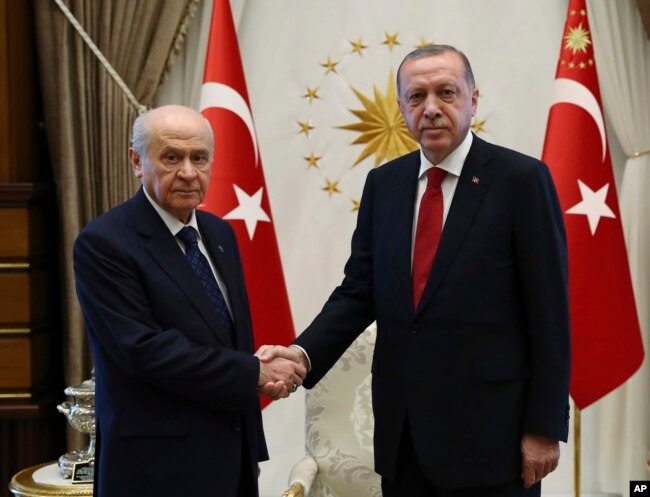 FILE - Devlet Bahceli, left, leader of the Nationalist Movement Party, or MHP, and the main ally of Turkey's President Recep Tayyip Erdogan, right, shake hands before a meeting at the presidential palace in Ankara, June 27, 2018.