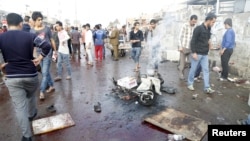 People gather at the site of suicide blasts in Baghdad's Sadr City, Feb. 28, 2016. The death toll from two suicide blasts in Baghdad's mainly Shi'ite district of Sadr City rose to 24 with more than 60 others wounded, police and medical sources said.