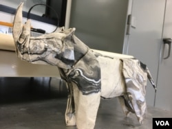 Robert Salazar donates his origami animals — such as this northern white rhino — to organizations and donors that help with wildlife conservation. (E. Lee/VOA)