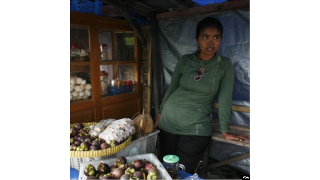 Jumilah, yang kehilangan 5 ekor sapi dan rumahnya sewaktu Merapi meletus, kini berjualan buah-buahan (foto: dok).