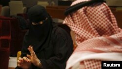 Saudi woman Fawzia al-Harbi, a candidate for local municipal council elections, gestures to one of her chaperones at a shopping mall in Riyadh November 29, 2015.