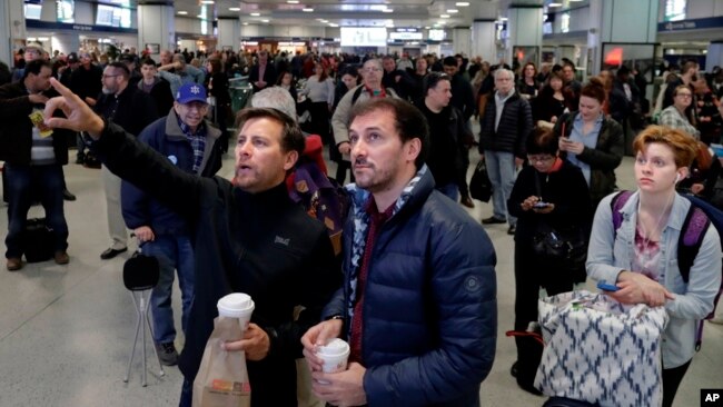 Los pasajeros miran hacia arriba a un tablero del horario del tren mientras que esperan en la estación de Penn de Nueva York, lunes, 3 de abril, 2017.