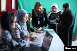 People register their names before voting at a polling station in Qamishli, Syria, Dec. 1, 2017.