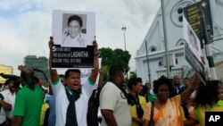 FILE - A protester holds a portrait of Lasantha Wickrematunge, a journalist who was killed, during a protest in Colombo, Sri Lanka.