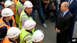 Russian President Vladimir Putin, right, speaks to workers as he visits Chernigovets coal mine in Beryozovsky, Kemerovo region, Russia, Monday, Aug. 27, 2018. (Alexei Druzhinin, Sputnik, Kremlin Pool Photo via AP)