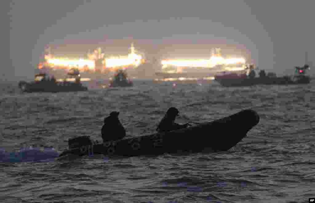 Nhân viên cứu hộ và thợ lặn tìm kiếm các nạn nhân bị mắc kẹt trong chiếc phà bị chìm&nbsp;ngoài khơi bờ biển phía nam gần đảo Jindo, ngày 22/4/2014.