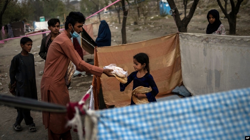 Para pengungsi internal Afghanistan menerima bantuan makanan di kamp sementara mereka di ibu kota Kabul (foto: dok). 