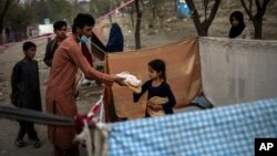 Para pengungsi internal Afghanistan menerima bantuan makanan di kamp sementara mereka di ibu kota Kabul (foto: dok). 