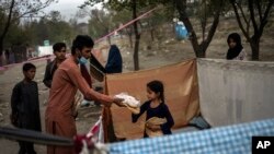 Displaced Afghans distribute food donations at an internally displaced persons camp in Kabul, Afghanistan, Sept. 13, 2021. 