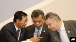 Cambodia's Deputy Prime Minister and Minister of Commerce Cham Prasidh (L) talks to EU Trade Commissioner Karel De Gucht (R), as ASEAN Secretary-General Surin Pitsuwan, listens during the opening ceremony of the 2nd ASEAN-EU business summit meeting in Phn