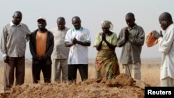 Rassemblement autour d'une tombe, où trois membres d’une famille assassinés ont été enterrés ensemble, à Jos, dans l'Etat du Plateau au Nigeria, le 28 décembre 2011.