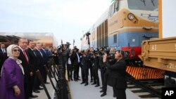 FILE - Turkey's President Recep Tayyip Erdogan, 2nd left, accompanied by his wife Emine, left, Azerbaijan's President Ilham Aliyev, 3rd left, and Georgia's Prime Minister Giorgi Kvirikashvili, 4th left, inaugurate the Baku-Tbilisi-Kars railway, at a ceremony in Baku, Azerbaijan, Oct. 30, 2017. 