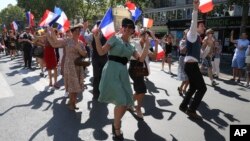 Gente vestida con ropa de la era de la Segunda Guerra Mundial baila en las calles de París el domingo, 25 de agosto, de 2019, durante la celebración del 75 aniversario de la liberación de París de la ocupación Nazi.