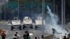 Des manifestants de l'opposition font face à des véhicules militaires près de la base aérienne Generalisimo Francisco de Miranda "La Carlota" à Caracas (Venezuela) le 30 avril 2019. REUTERS / Carlos Garcia Rawlins