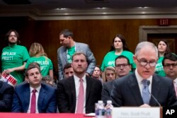 Members of the audience wear shirts that read "Impeach Pruitt" as EPA Administrator Scott Pruitt, right, testifies before a Senate Appropriations subcommittee on budget on Capitol Hill in Washington, May 16, 2018.