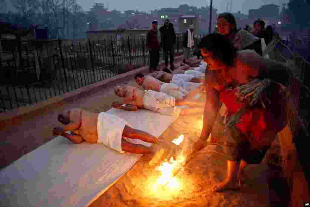 Nepalese Hindu devotees roll on the ground on the banks of Hanumante River on the last day of Madhav Narayan festival in Bhaktapur.