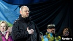 Mantan Menteri Perekonomian Ukraina, Arseny Yatseniuk (depan) berdiri di panggung saat bergabung bersama para pengunjuk rasa di Lapangan Merdeka, Kyiv, Ukraina (26/2).