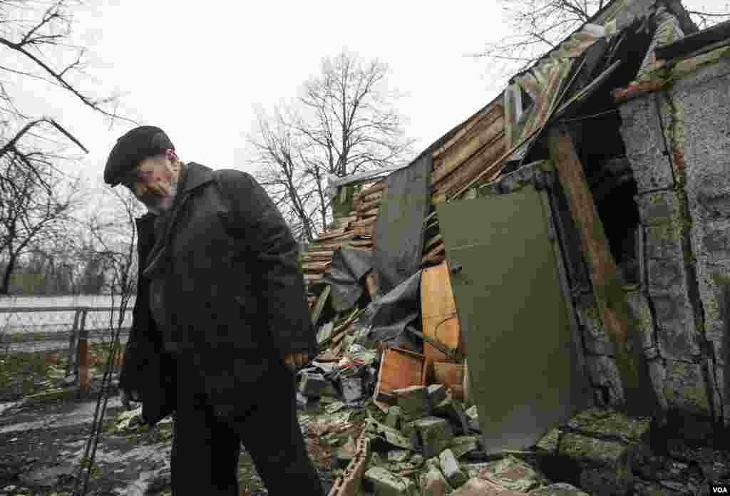 A man walks past a house damaged by recent shelling in Yenakieve, northeast of Donetsk, Feb. 2, 2015.