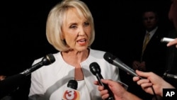 In this June 15, 2010 file photo, Arizona Gov. Jan Brewer speaks in Phoenix. With the scrawl of a pen, Brewer awakened a dormant, but politically explosive issue of illegal immigration, sending shock waves across the political spectrum in an election year