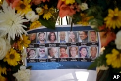 FILE - Pictures of Wednesday's shooting victims are displayed at a makeshift memorial site in San Bernardino, Calif., Dec. 7, 2015.