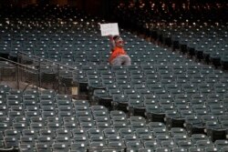 San Francisco Giants mascot Lou Seal holds up a sign during the fifth inning of an exhibition baseball game between the Giants and the Oakland Athletics in San Francisco, Tuesday, July 21, 2020. (AP Photo/Jeff Chiu)