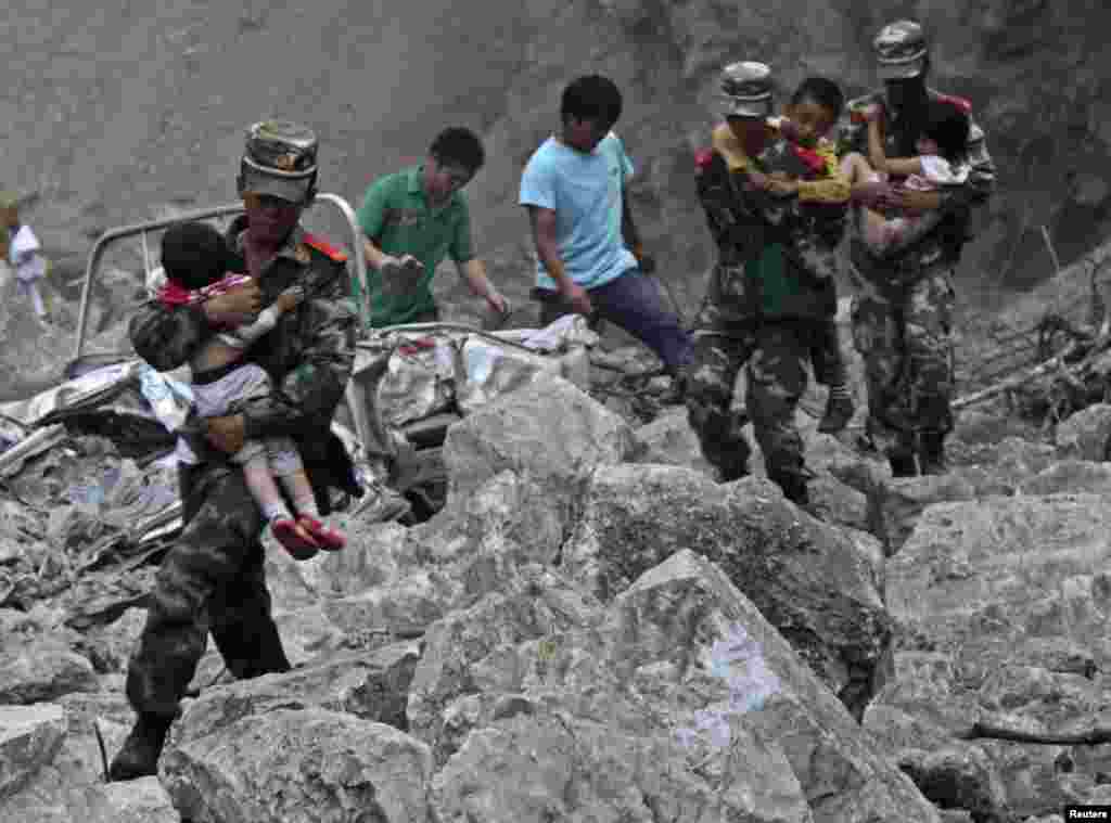 Soldiers carry children as locals follow them towards safer area after two earthquakes hit Zhaotong, Yunnan province, Sept. 7, 2012.