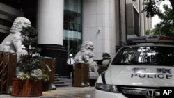 资料照：中国广州中级法院大门外的警车、石狮子与保安。（2015年5月7日）