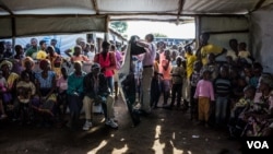 At 8 am the health post operated by Medical Teams International at Kuluba collection point is jam-packed with South Sudanese refugees waiting to undergo their first health screening. (N. Jidovanu/VOA)